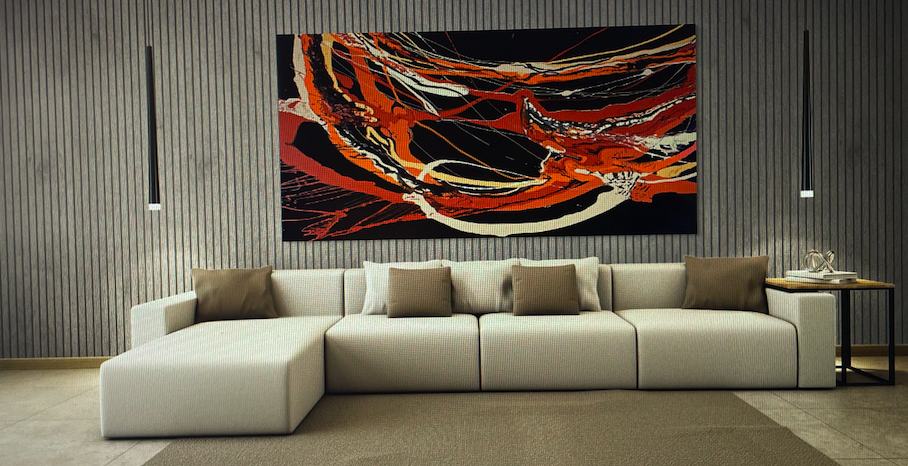 Wide abstract painting above a modern sectional sofa