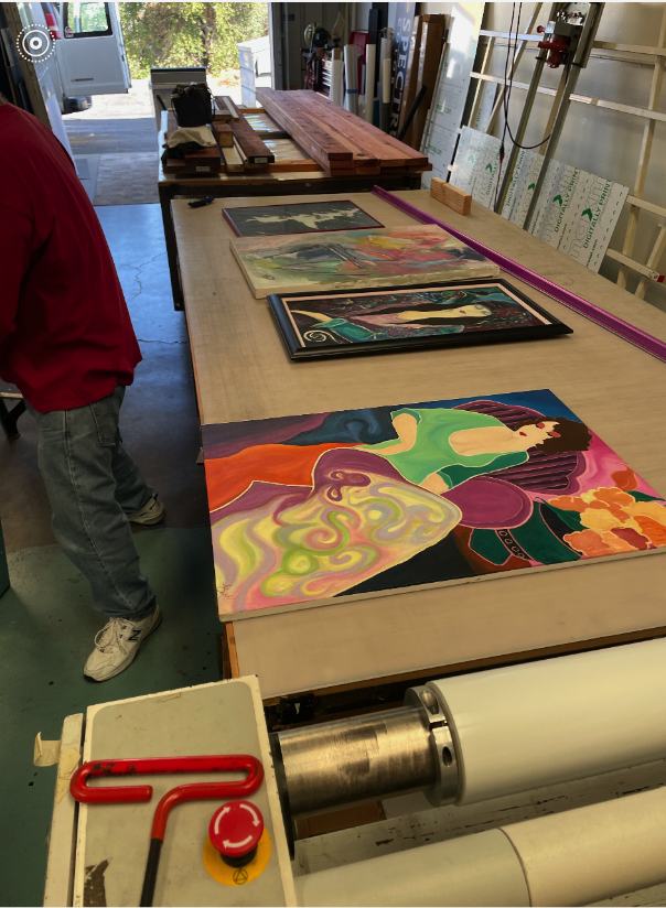 Paintings laid out on a worktable in the studio