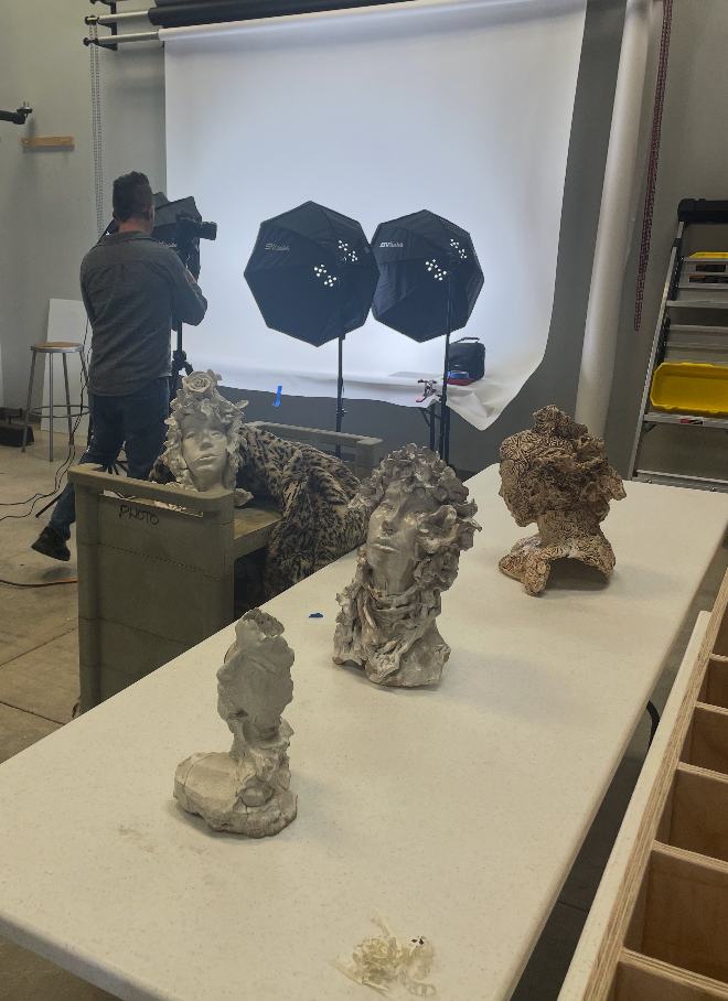 A collection of ceramic busts on a table during a photo shoot